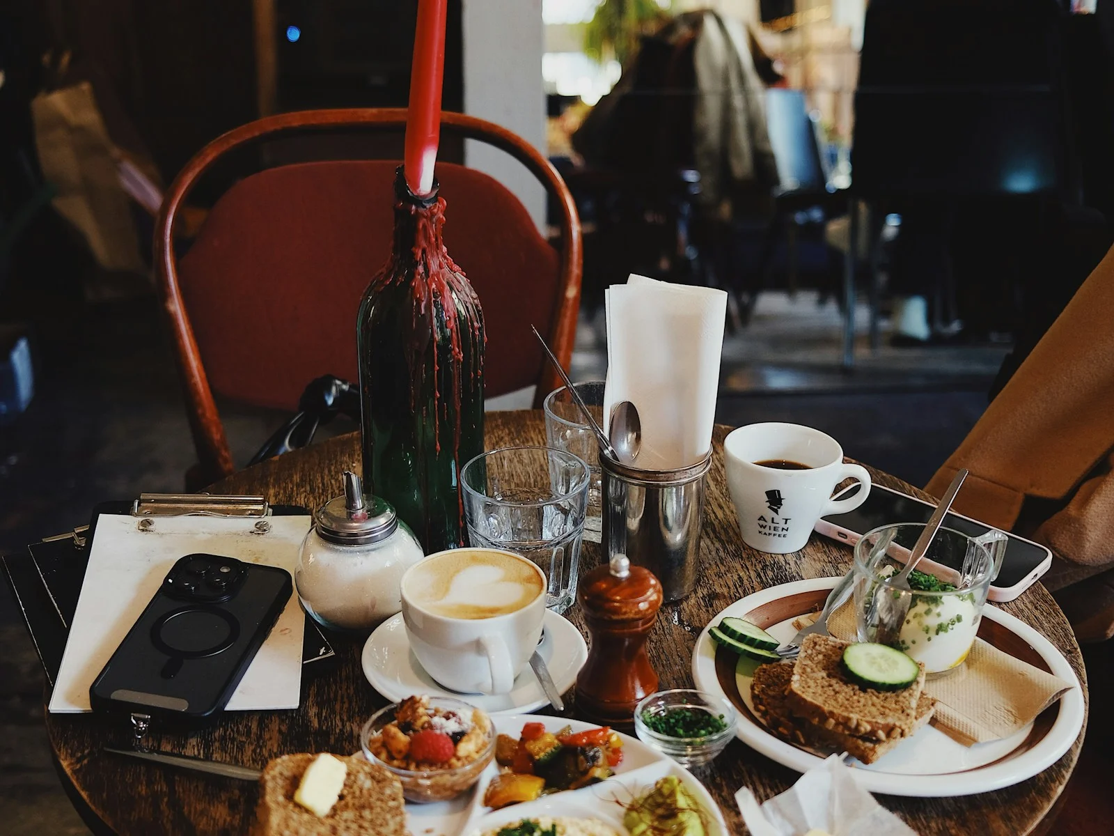 Gedeckter Cafétisch mit Kaffee, Brot, Aufstrichen und Frühstückstellern